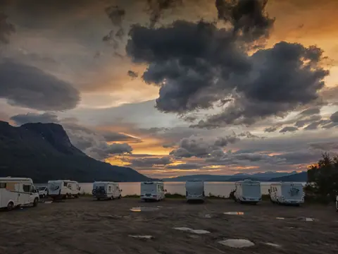 Bobiler oppstilt på en campingplass i solnedgang